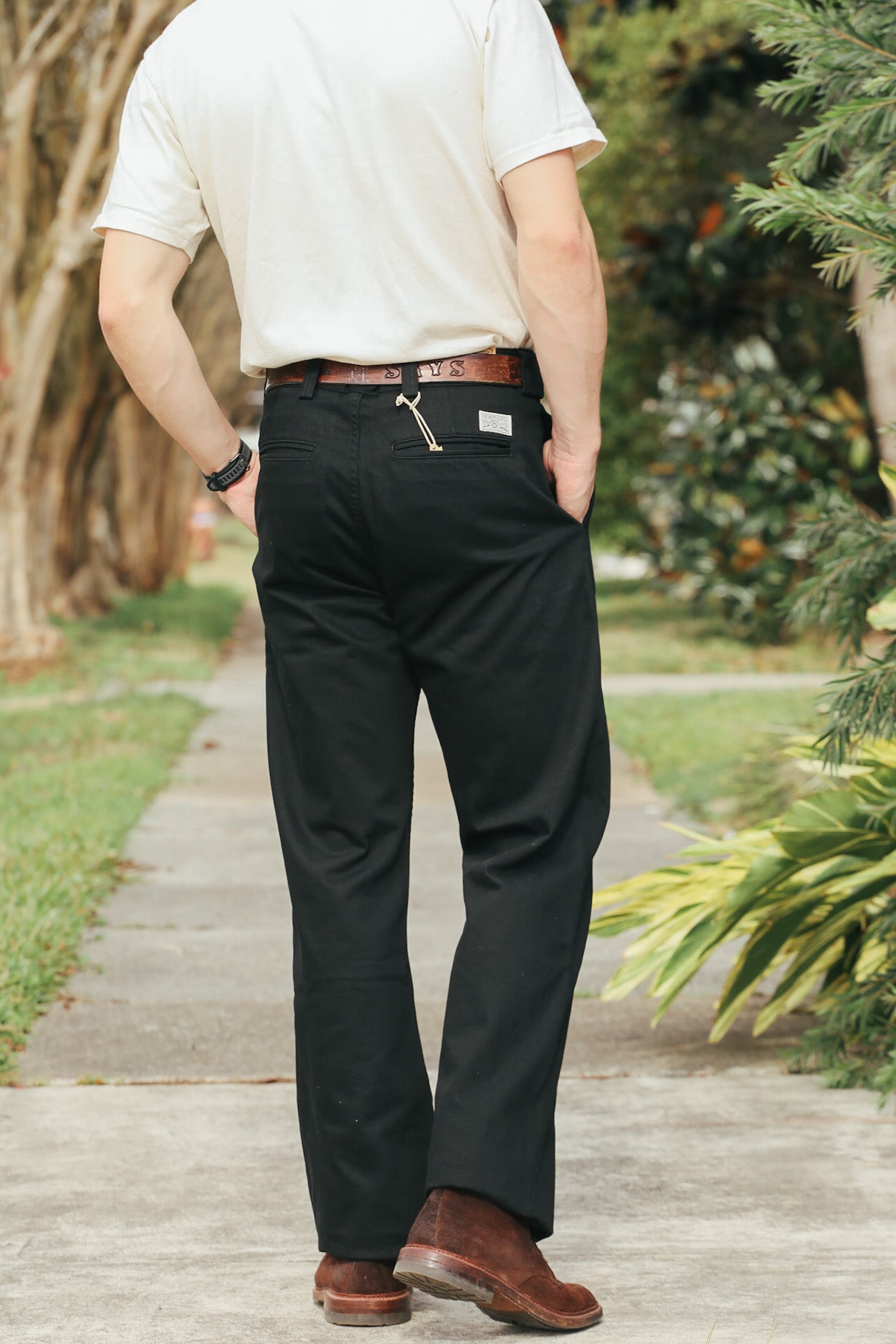 Person wearing black pants and a white shirt in an outdoor setting