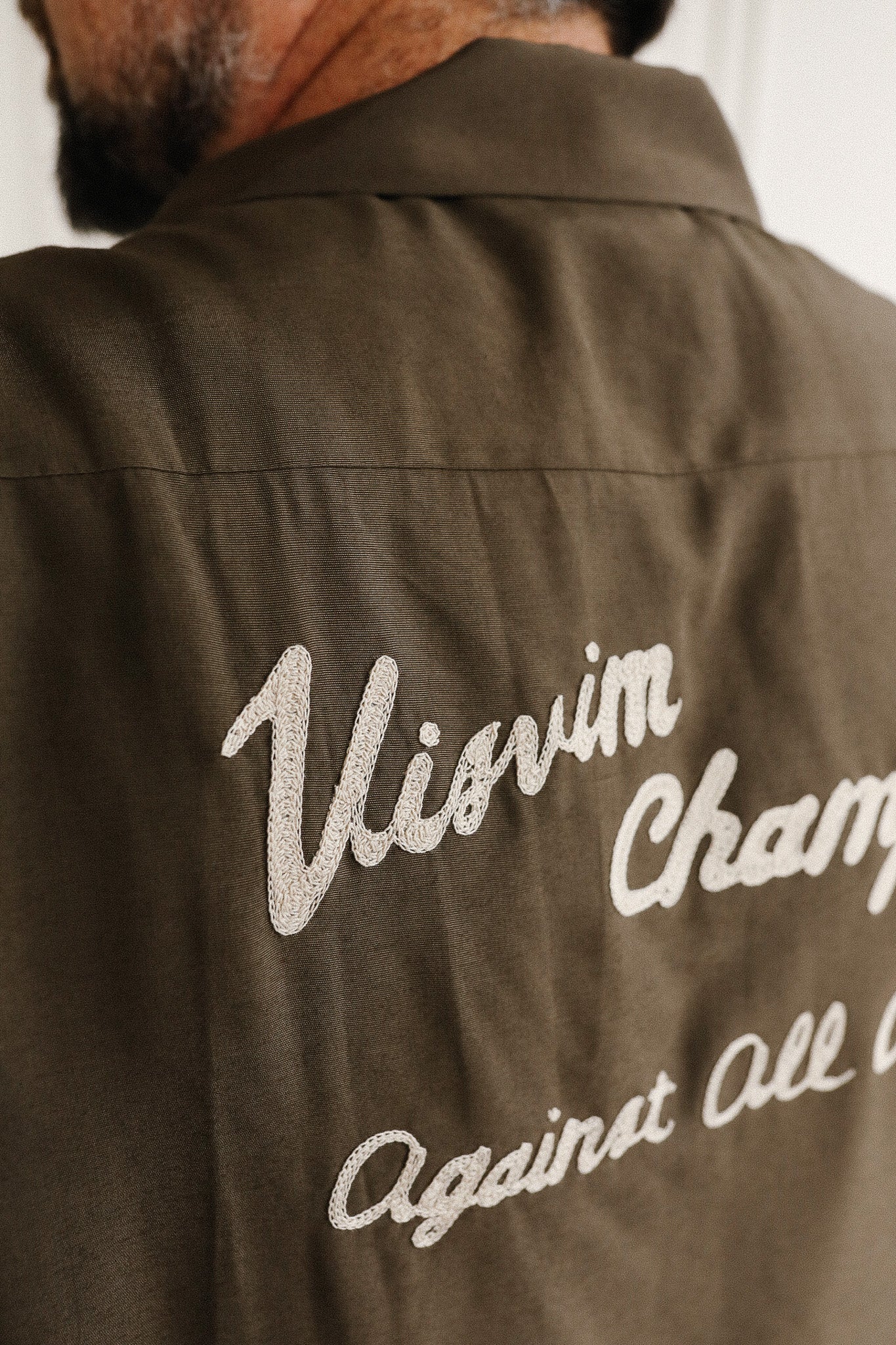 Brown jacket with 'Visvim' and 'Cham' text on the back