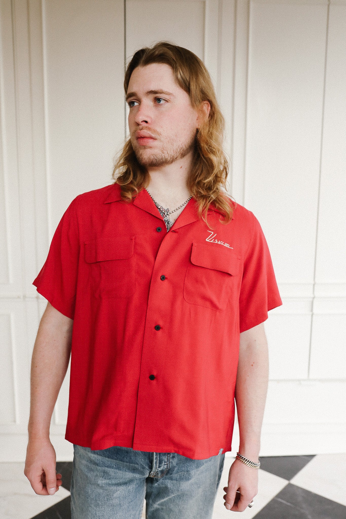 Person wearing a red shirt with a logo indoors