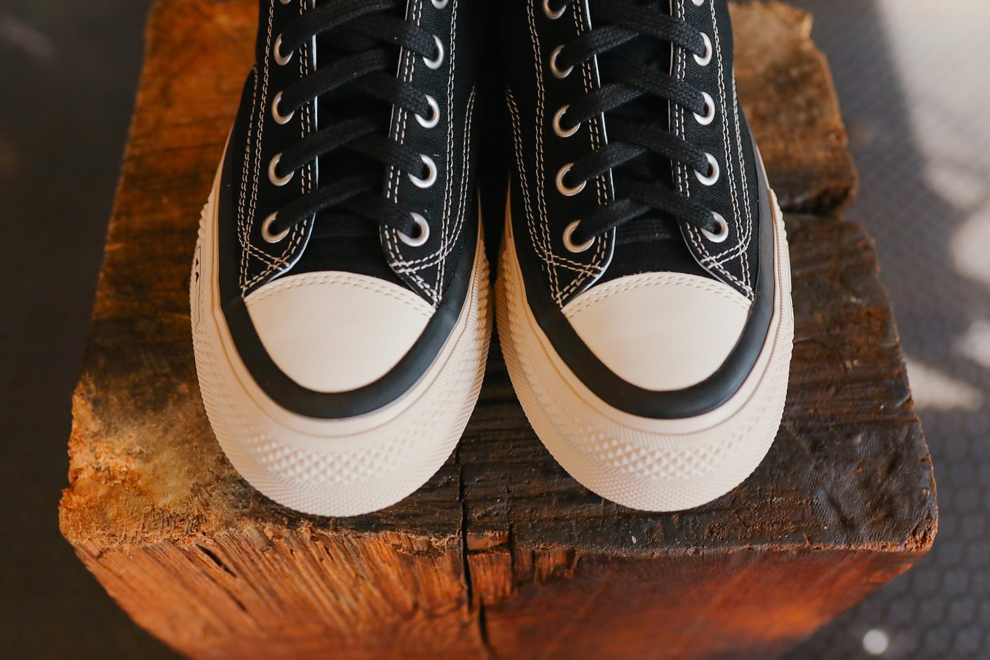 Black and white sneakers on a wooden block