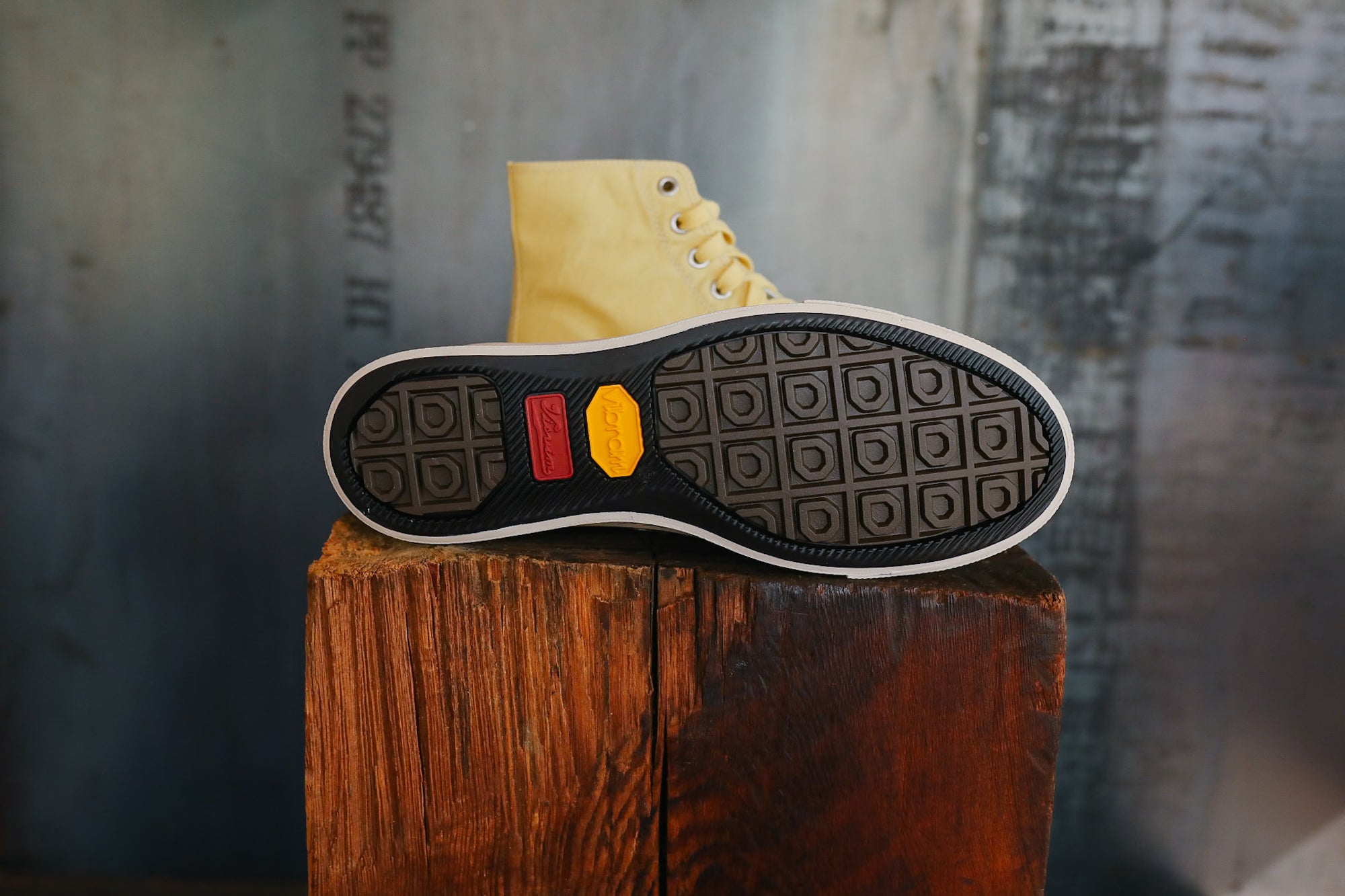 Close-up of a shoe sole with a textured pattern on a wooden block against a blurred background