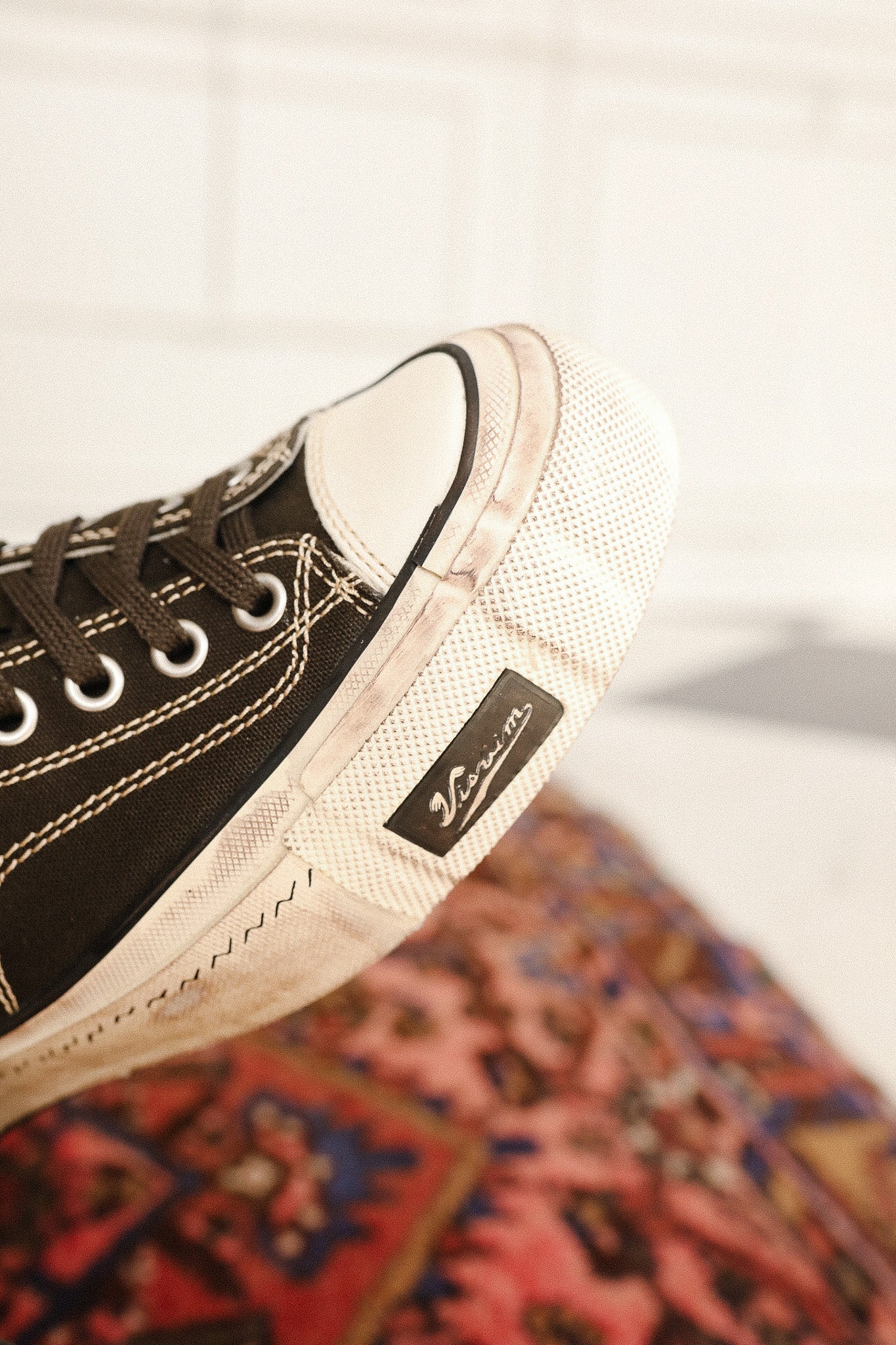 Black and white sneaker on a patterned rug