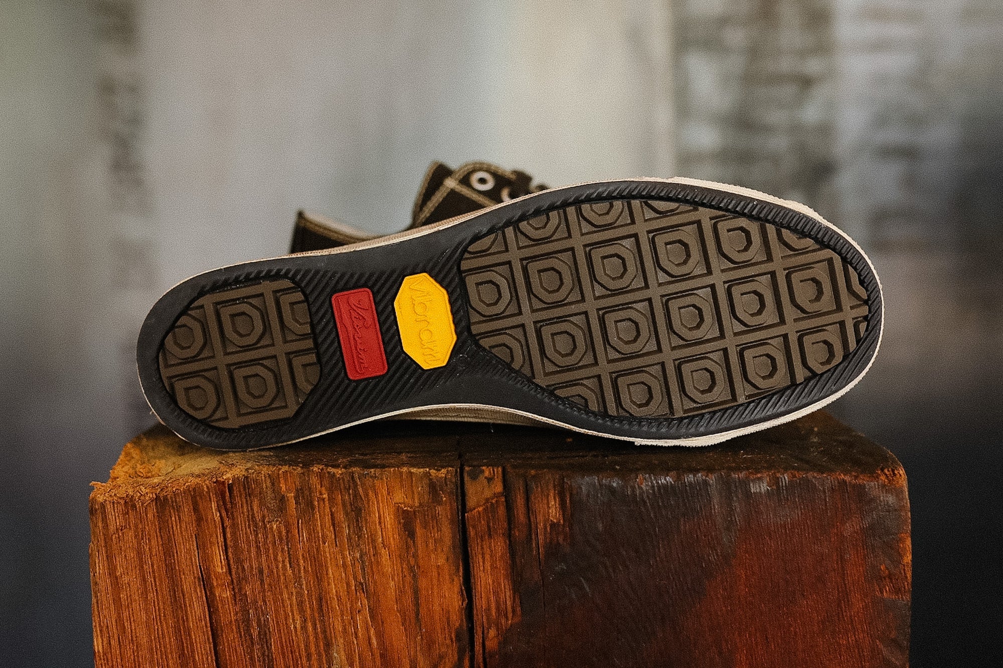 Close-up of a shoe sole with a textured pattern on a wooden block.
