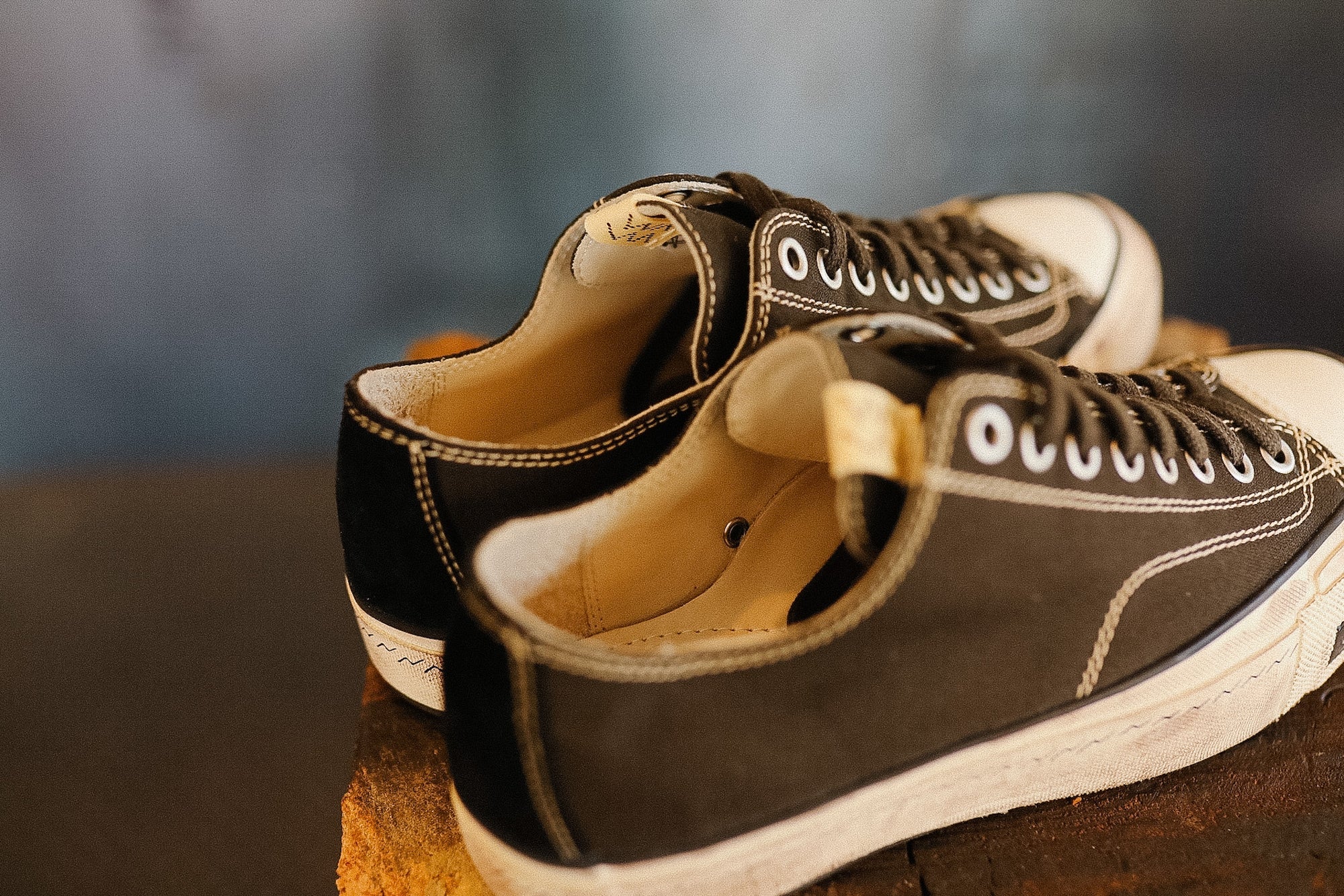 Pair of black and white sneakers on a reflective surface with a blurred background