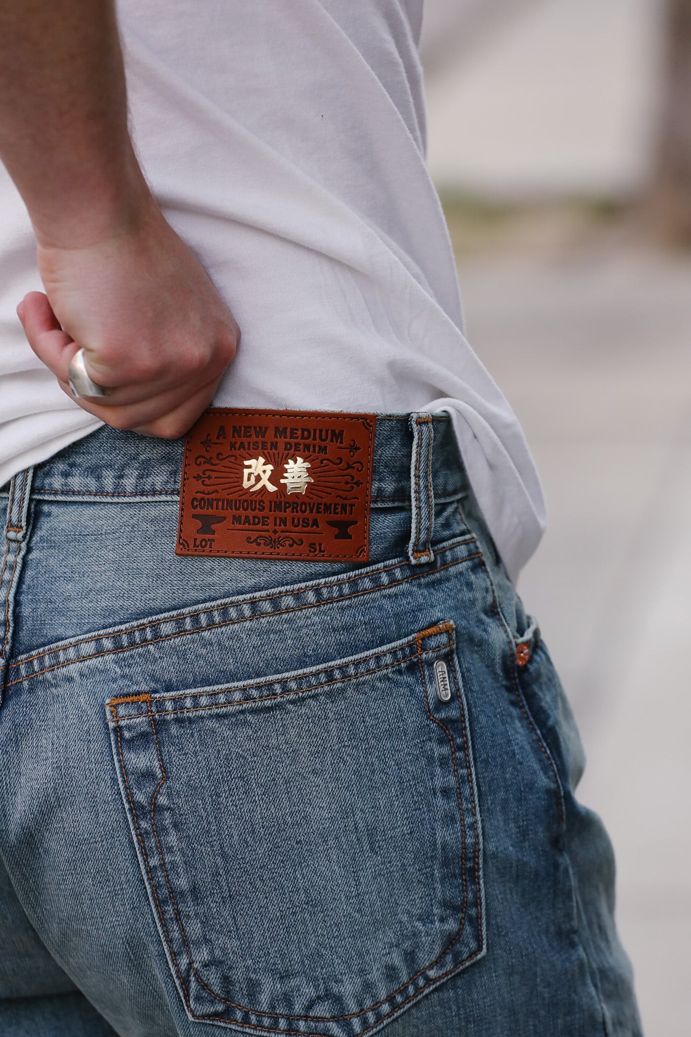 Close-up of blue jeans with a brand label on the back pocket, blurred background